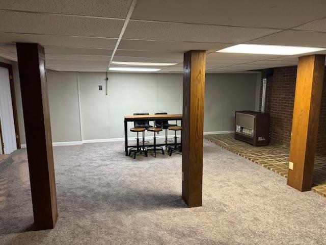 1409 Roper Road Bolivar, TN 38008 - Photo 25 of 33 Basement with carpet, a wood stove, and a drop ceiling