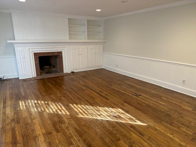 1409 Roper Road Bolivar, TN 38008 - Photo 7 of 33 Unfurnished living room with built in shelves, dark hardwood / wood-style flooring, ornamental molding, and a fireplace