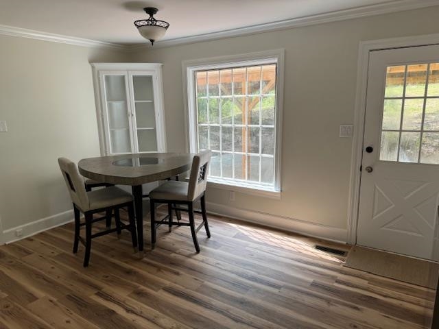 1409 Roper Road Bolivar, TN 38008 - Photo 10 of 33 Dining room with ornamental molding, a wealth of natural light, and dark hardwood / wood-style floors