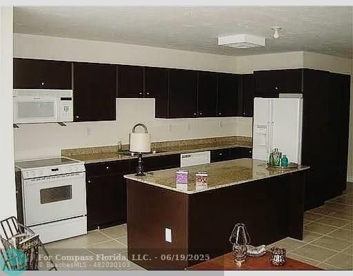 236 East 56th Street Hialeah, FL 33013 - Photo 5 of 7 a kitchen with a sink and a stove