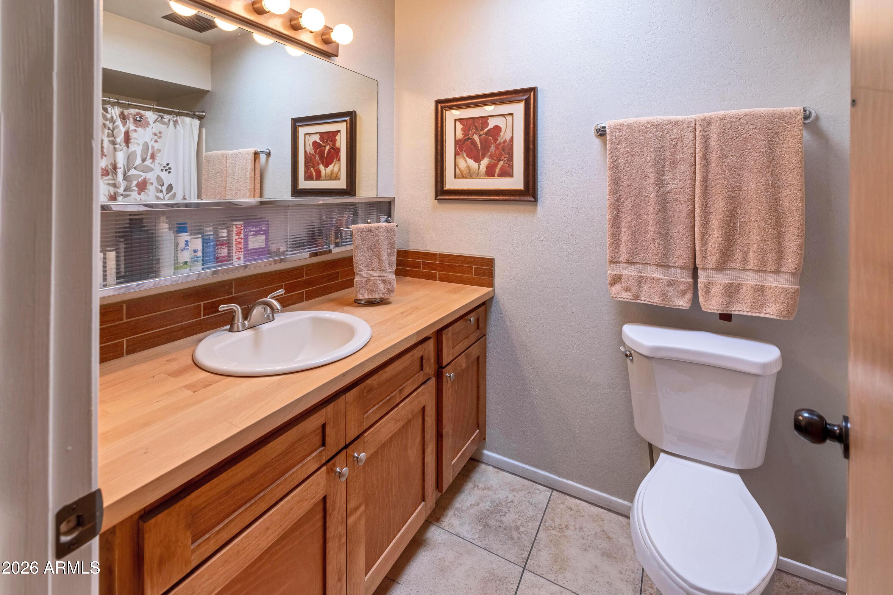 9111 North Oracle Road, Unit 110 Tucson, AZ 85704 - Photo 16 of 27 a bathroom with a toilet sink and mirror