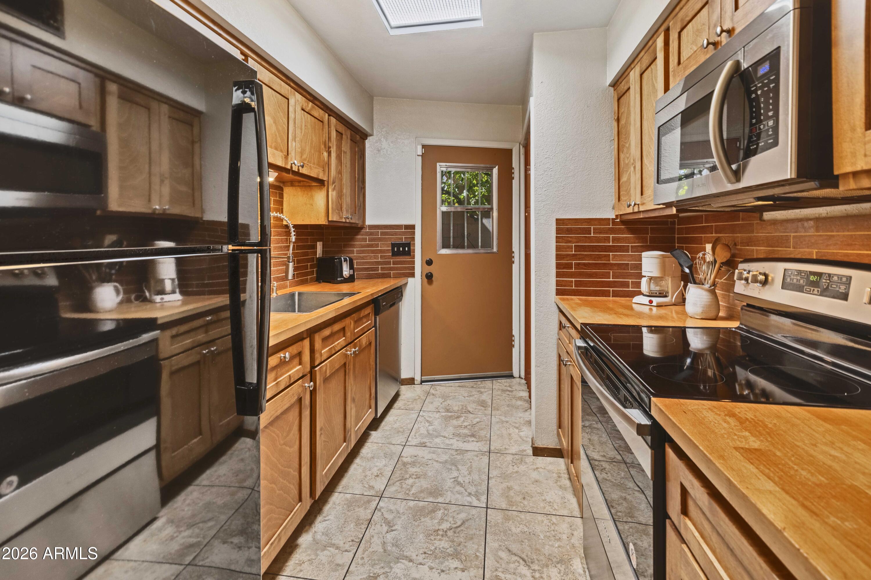 9111 North Oracle Road, Unit 110 Tucson, AZ 85704 - Photo 8 of 27 a kitchen with stainless steel appliances granite countertop a stove and a sink