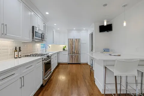 a large kitchen with stainless steel appliances granite countertop a sink stove and refrigerator