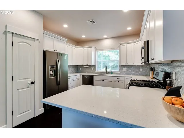 a kitchen with stainless steel appliances granite countertop a refrigerator sink and cabinets