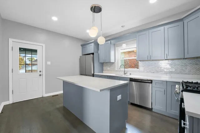 a kitchen that has a sink a window and stainless steel appliances