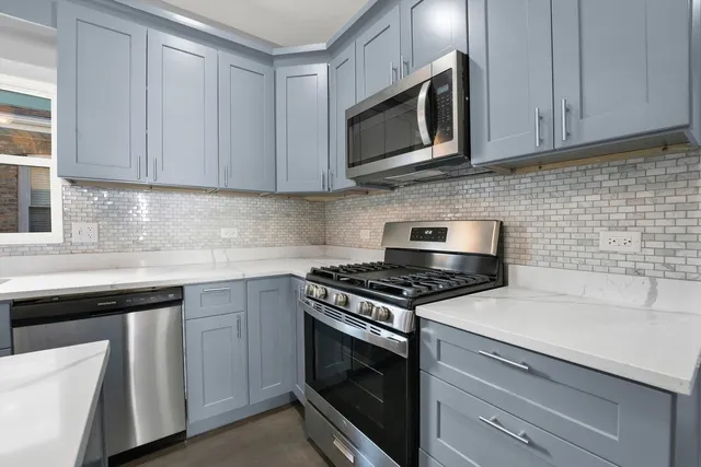 a kitchen with cabinets stainless steel appliances and sink