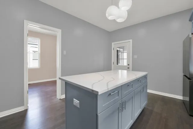 a kitchen with a stove and a wooden floor