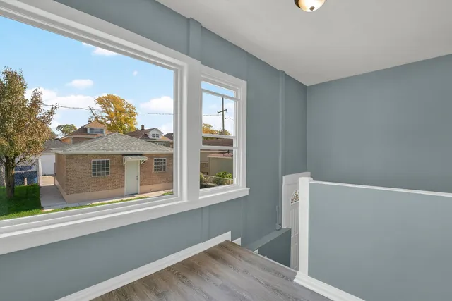 a view of a small space with wooden floor and a window
