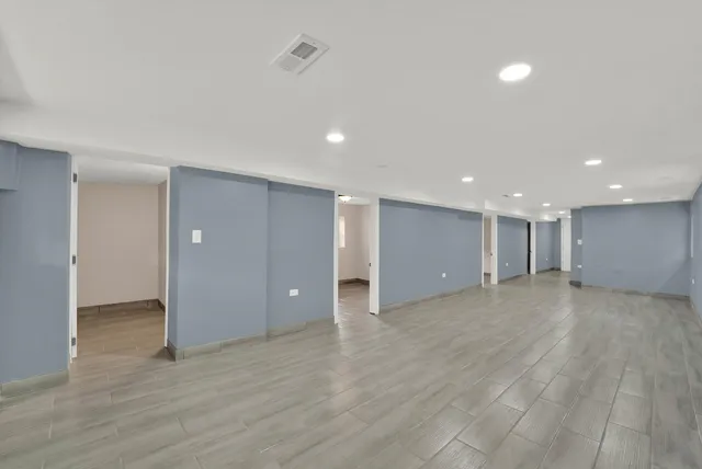 a view of an empty room with wooden floor