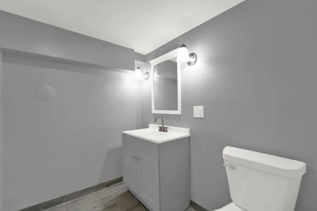a bathroom with a sink toilet and mirror