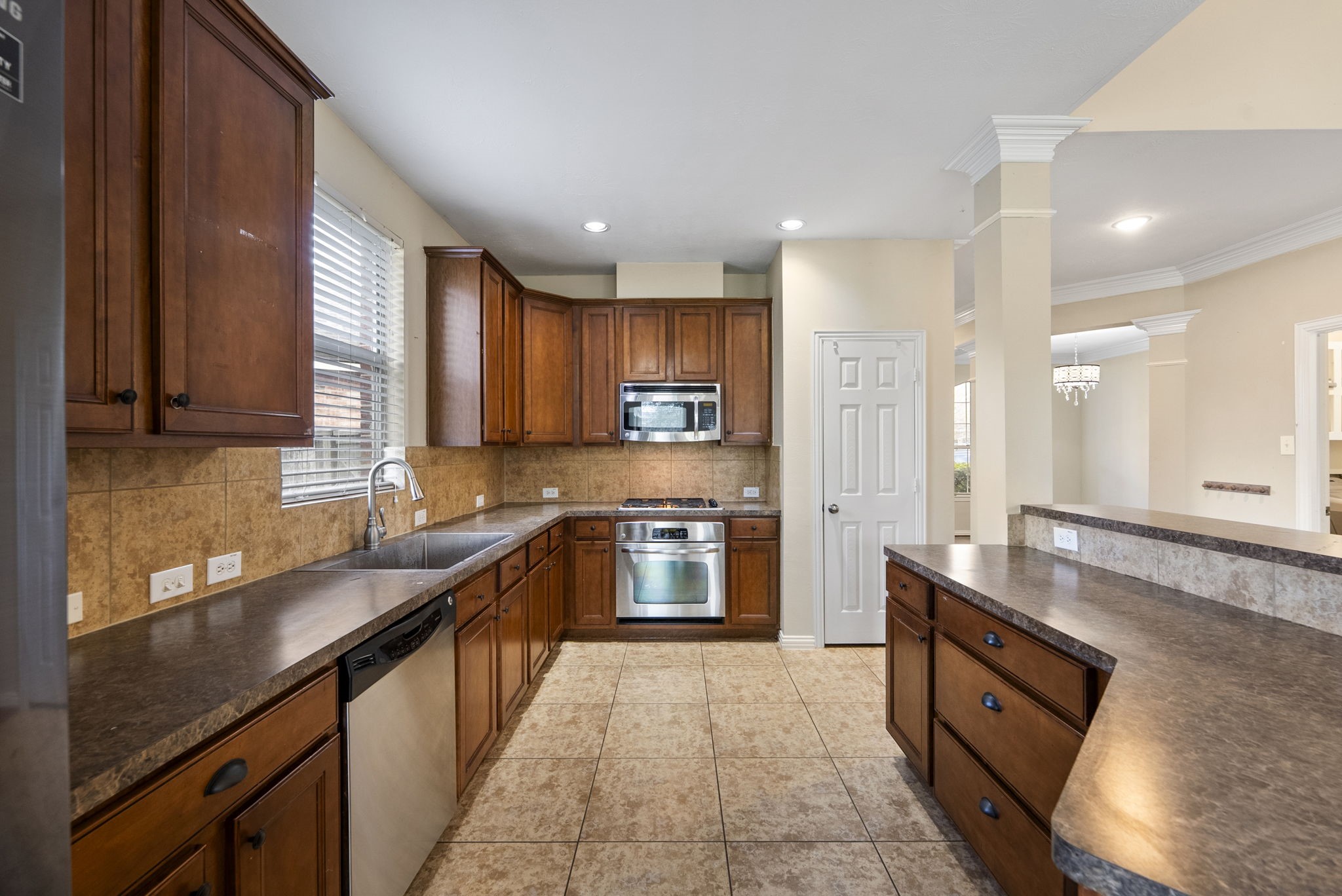 9526 Tartan Manor Street Spring, TX 77379 - Photo 14 of 42 a large kitchen with stainless steel appliances granite countertop a sink stove and refrigerator