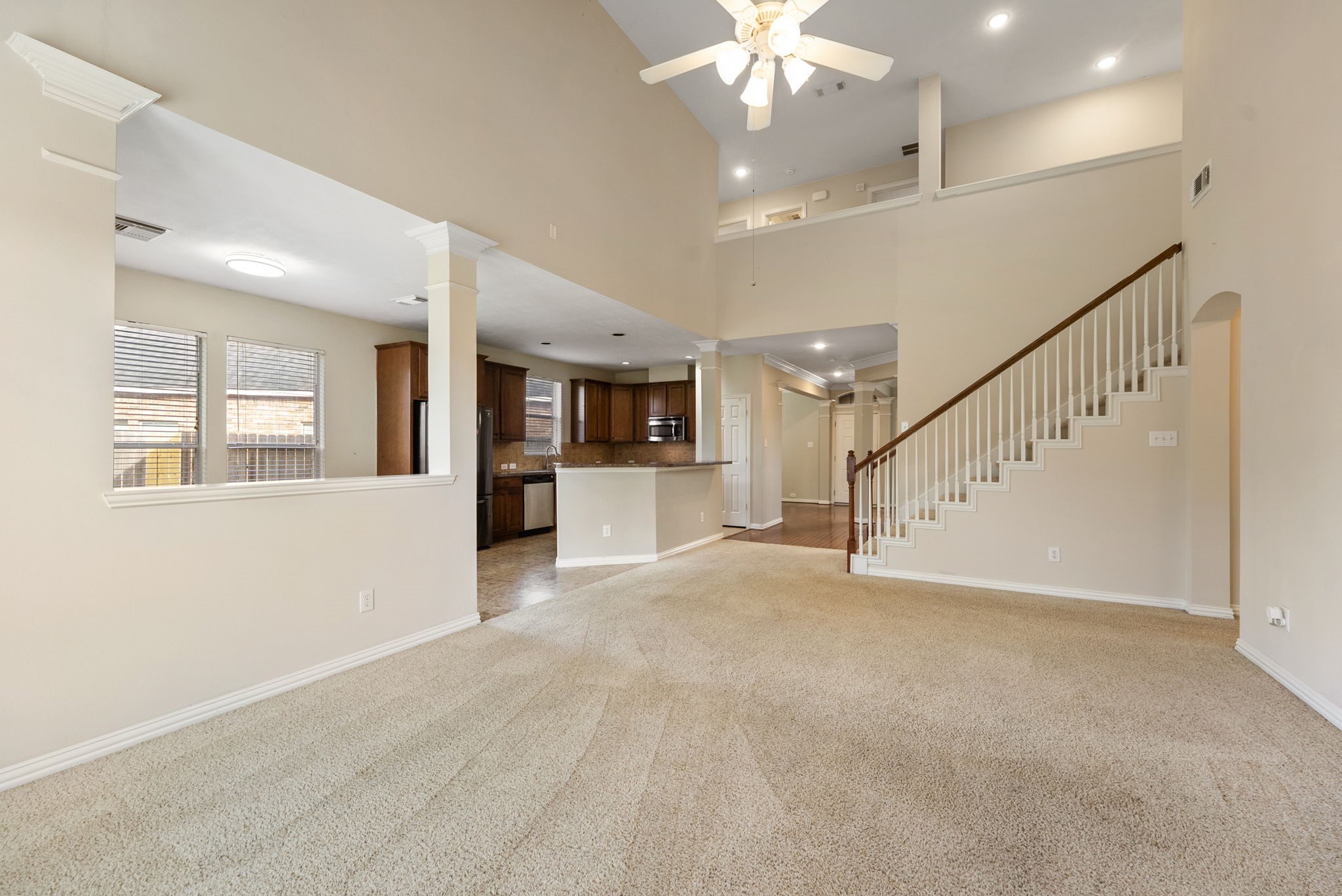 9526 Tartan Manor Street Spring, TX 77379 - Photo 23 of 42 a view of an empty room with wooden floor and a kitchen