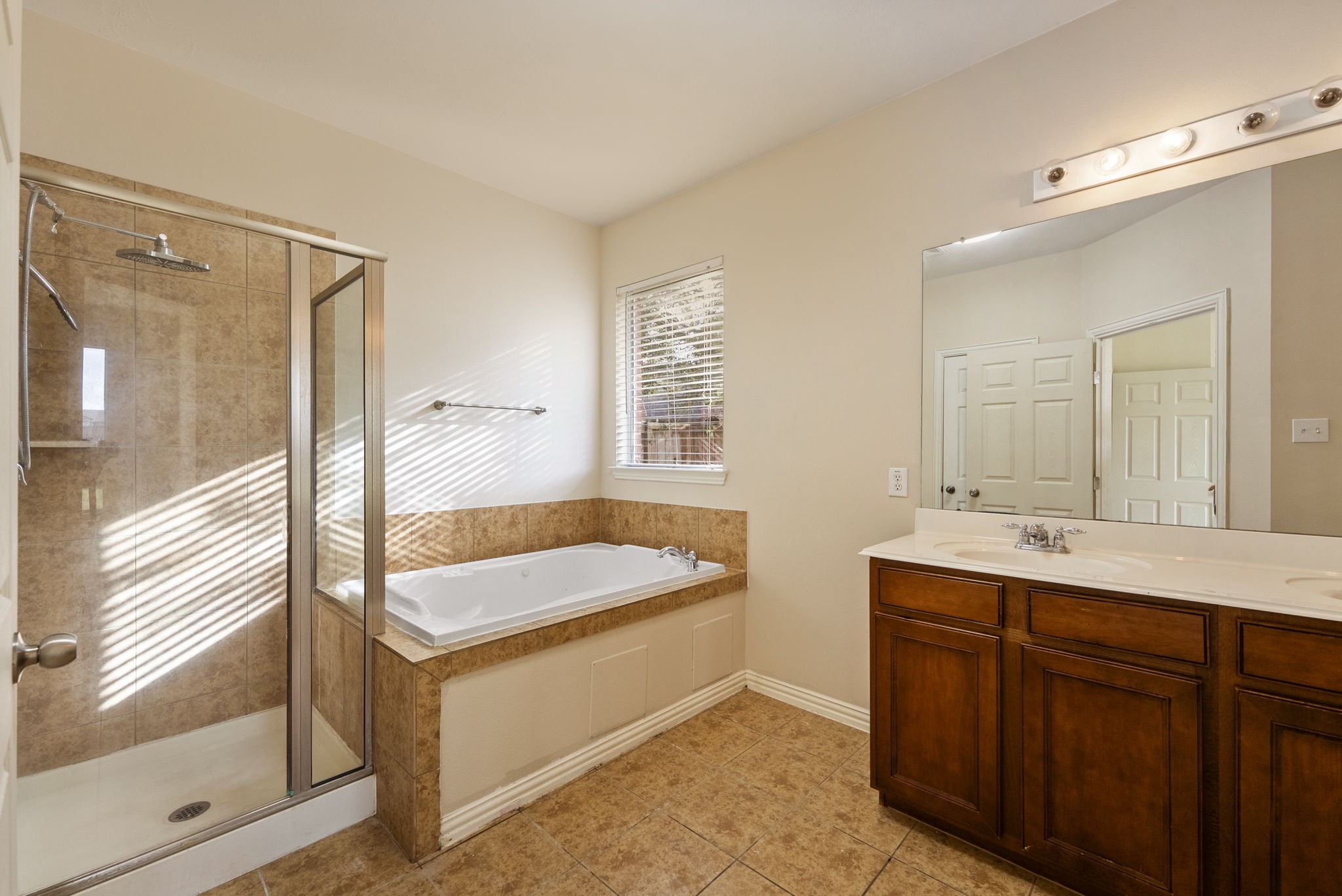 9526 Tartan Manor Street Spring, TX 77379 - Photo 26 of 42 a bathroom with a tub a sink and mirror