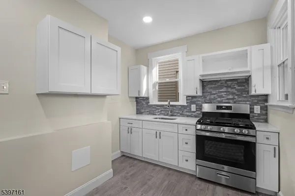 a kitchen with white cabinets and appliances