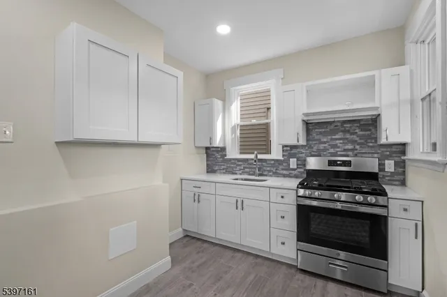 a kitchen with white cabinets and appliances