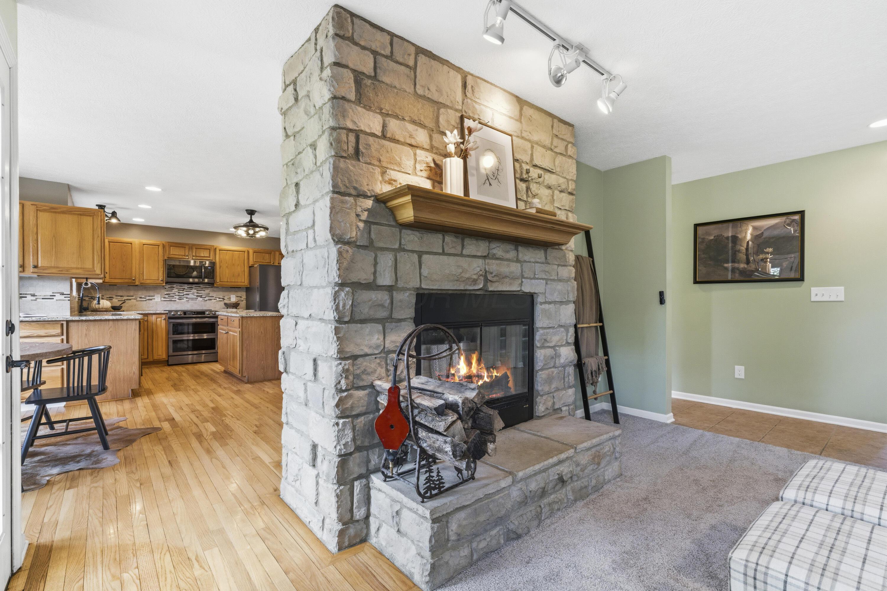 8507 Benner Road Johnstown, OH 43031 - Photo 12 of 69 Family Room with double-sided fireplace with bay window! NEW Carpet & NEW ceiling fan.