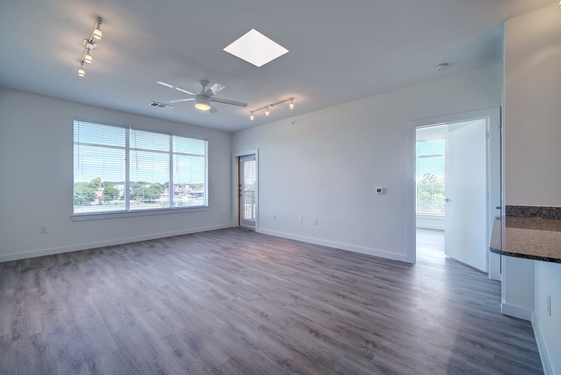 13130 Pond Springs Road, Unit 3214 Austin, TX 78729 - Photo 9 of 40 Spare room featuring rail lighting, dark wood-style flooring, a skylight, and a ceiling fan
