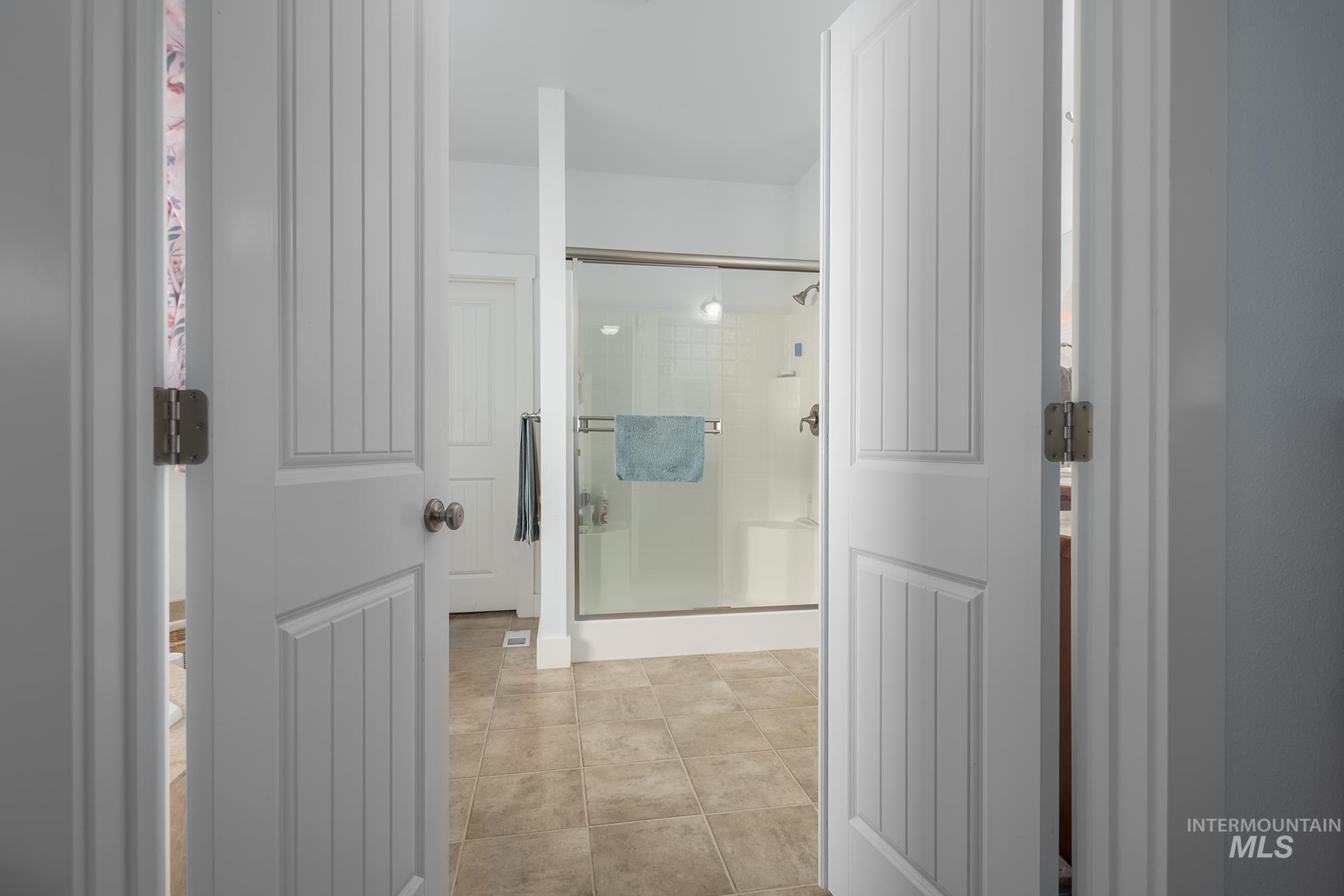 420 West Indianhead Road Weiser, ID 83672 - Photo 23 of 40 Bright bathroom featuring a glass-enclosed shower with a white base and a large shower head