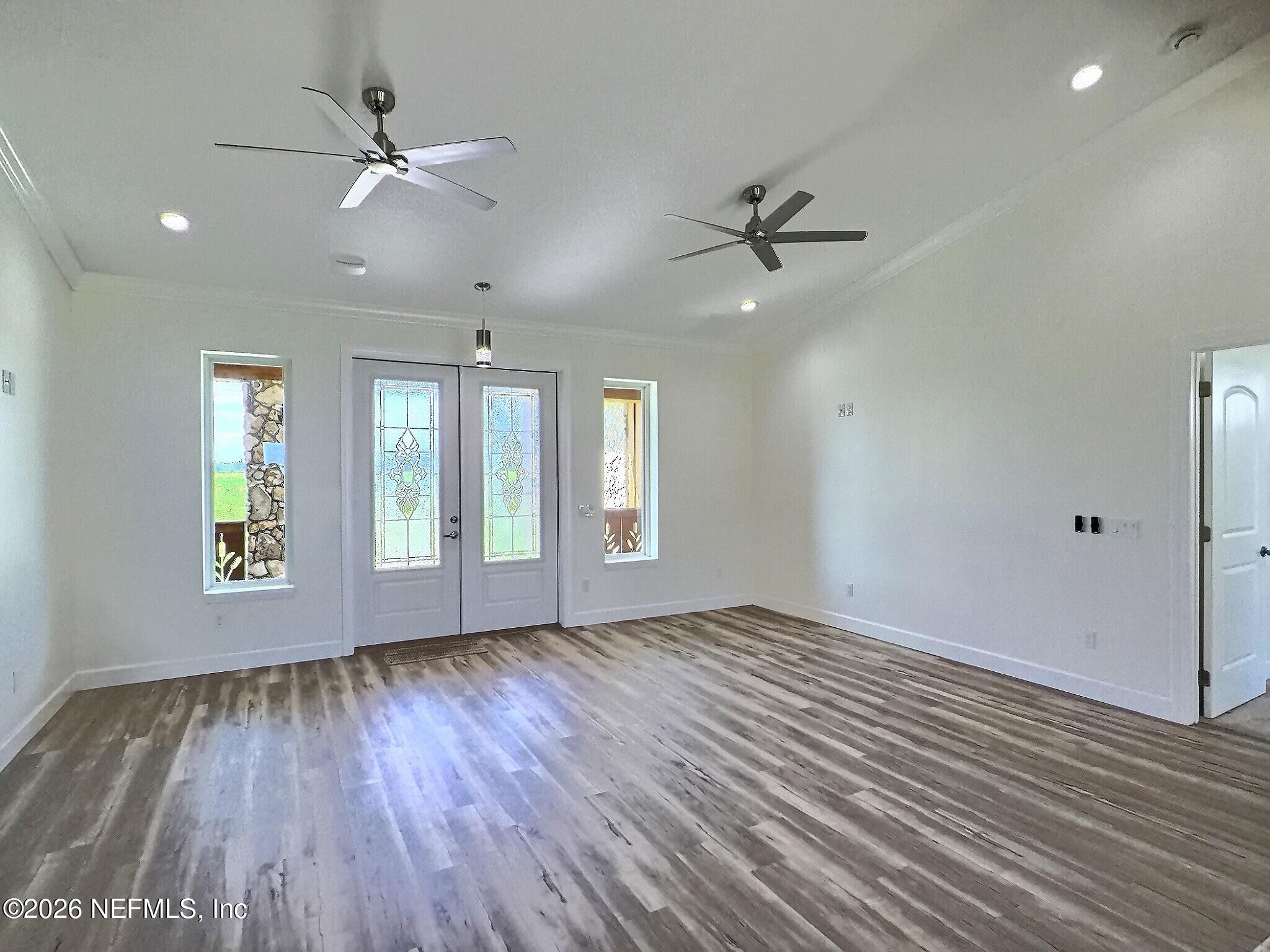 159 Mays Cove Road East Palatka, FL 32131 - Photo 9 of 62 a view of an empty room with a window and wooden floor