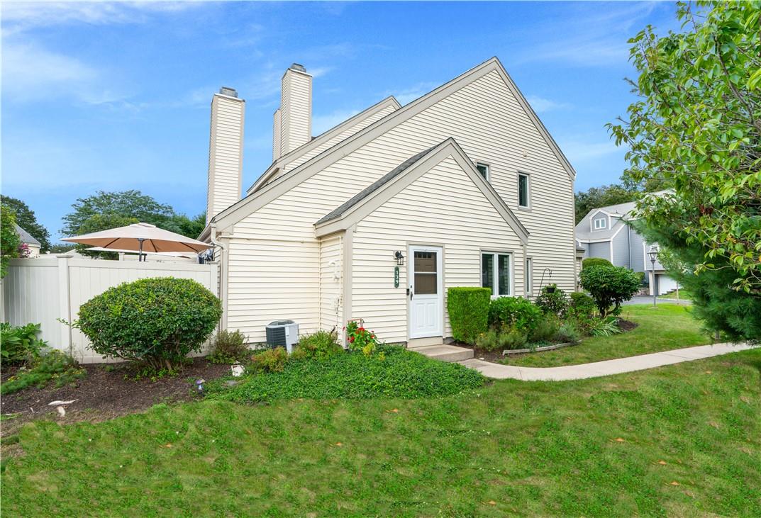 a view of a house with a yard and potted plants