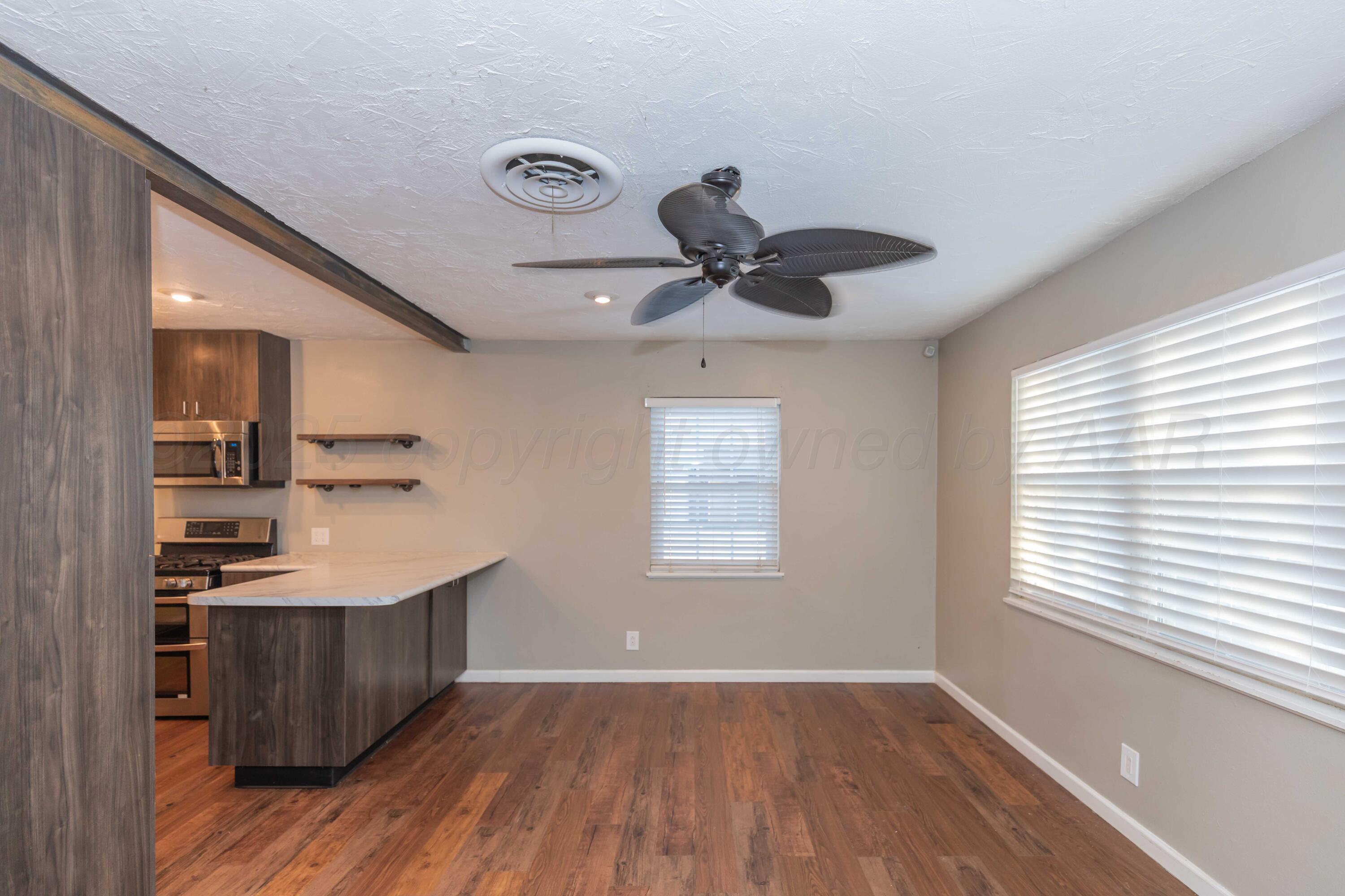 4516 South Bonham Street Amarillo, TX 79110 - Photo 5 of 30 a kitchen with stainless steel appliances granite countertop a sink a window and wooden floor