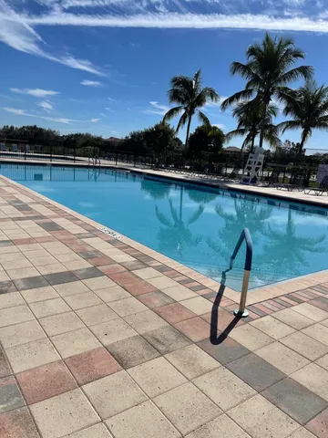 a view of a lake with a bench and trees in the background