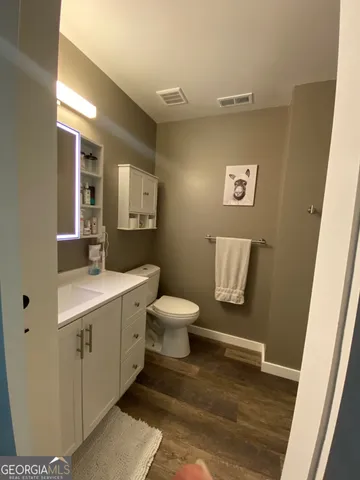 a bathroom with a toilet sink a mirror and vanity
