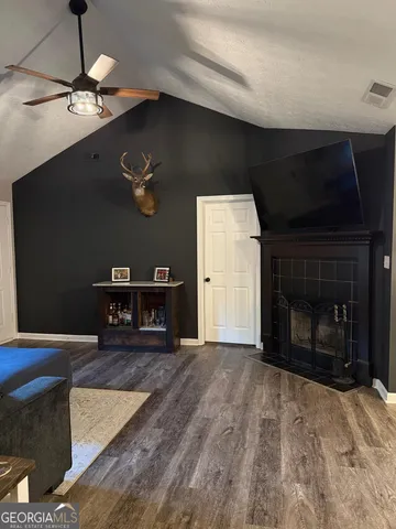 a living room with furniture a fireplace and a flat screen tv