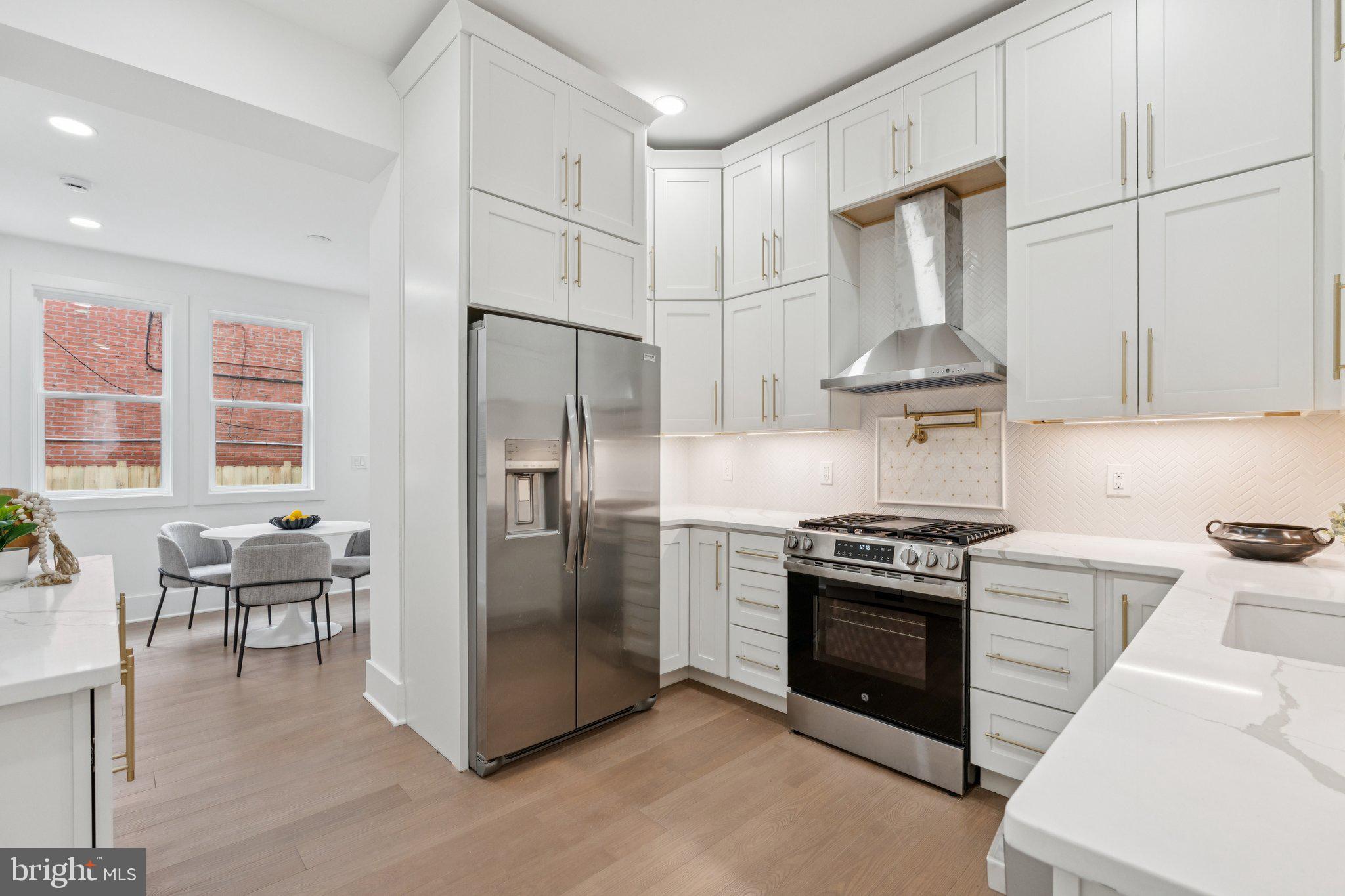 1827 North Capitol Street Northeast Washington, DC 20002 - Photo 12 of 53 a kitchen with stainless steel appliances a stove a refrigerator and chairs