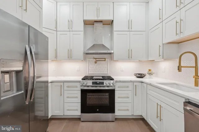 a kitchen with stainless steel appliances granite countertop white cabinets and a stove