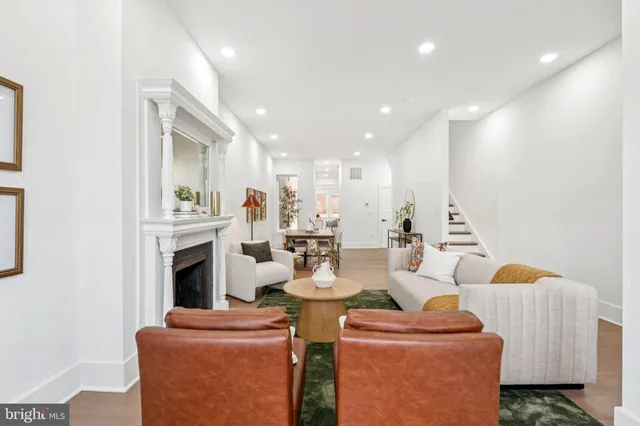 a living room with furniture a fireplace and kitchen view