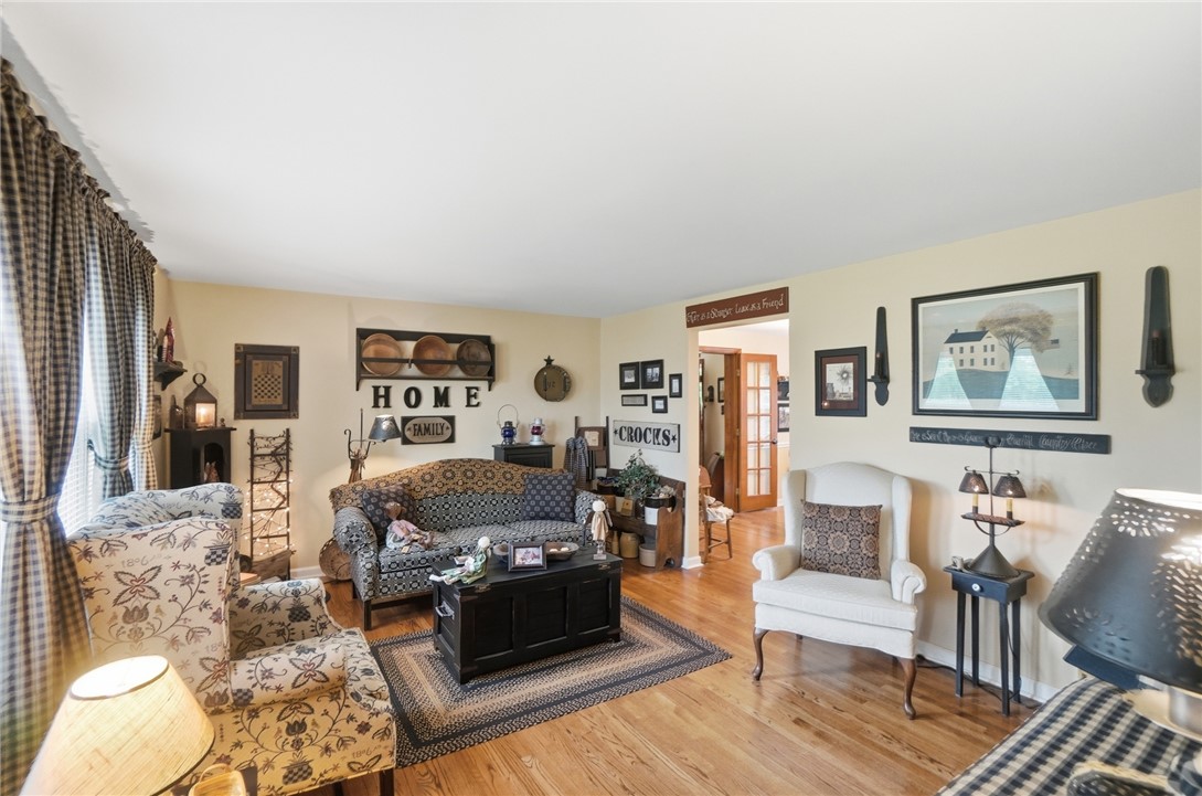 4170 Johnson Road Springfield, OH 45502 - Photo 11 of 54 Hardwood floors grace this well-lit living area, offering a warm and inviting space for relaxation.