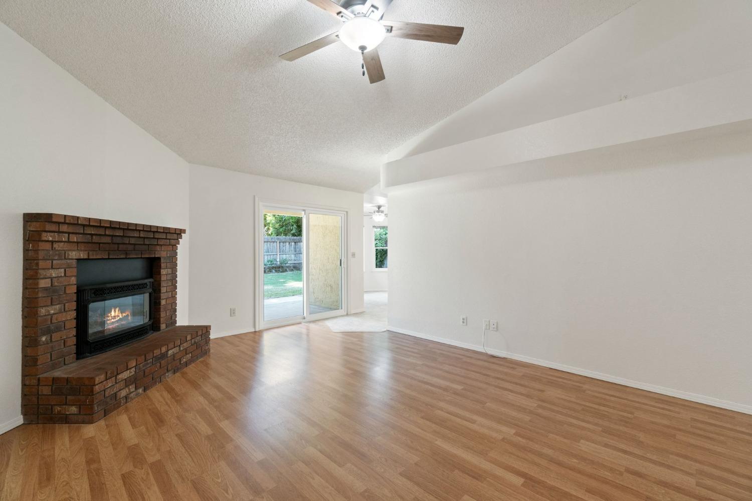 2500 Mitchell Avenue Clovis, CA 93611 - Photo 16 of 31 a view of an empty room with wooden floor fireplace and a window