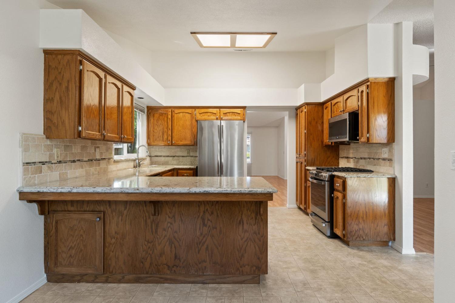 2500 Mitchell Avenue Clovis, CA 93611 - Photo 18 of 31 a kitchen with stainless steel appliances granite countertop a sink a stove and refrigerator