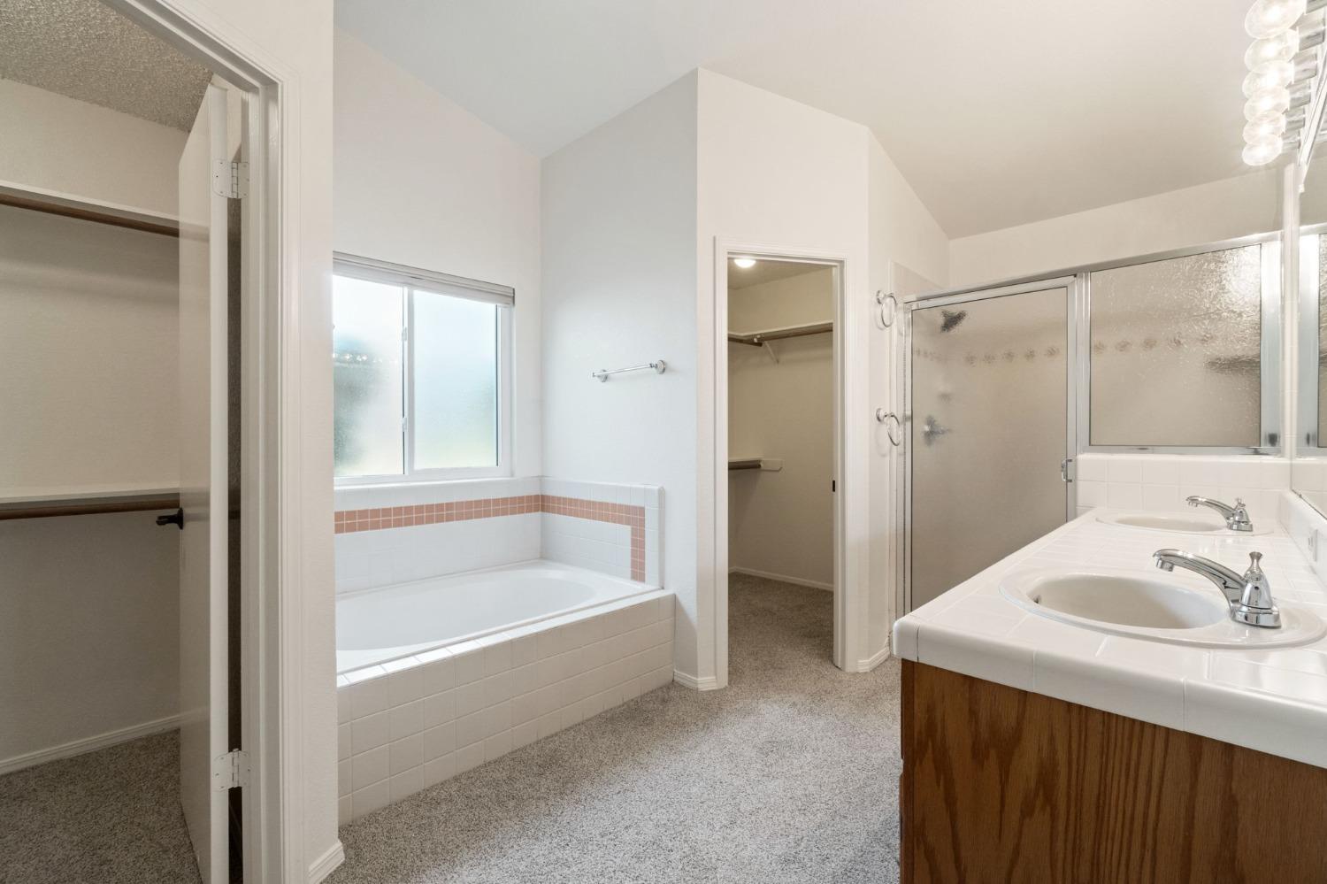 2500 Mitchell Avenue Clovis, CA 93611 - Photo 7 of 31 a bathroom with a tub sink a mirror and a shower