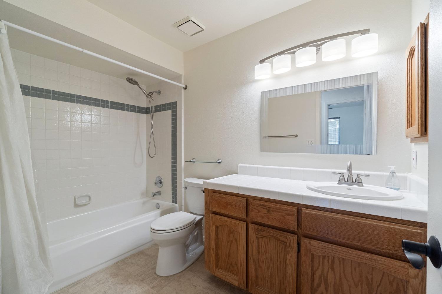 2500 Mitchell Avenue Clovis, CA 93611 - Photo 8 of 31 a bathroom with a toilet a sink and a bathtub