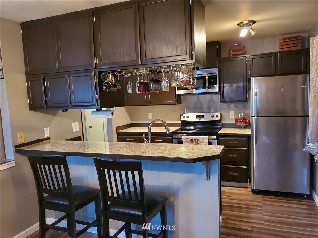307 R Street Northeast Auburn, WA 98002 - Photo 8 of 20 a kitchen with stainless steel appliances granite countertop a sink refrigerator and cabinets