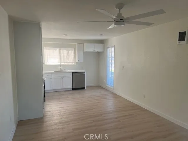 a large white kitchen with a white cabinets and wooden floor