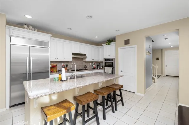 a kitchen with stainless steel appliances granite countertop a refrigerator and a stove top oven