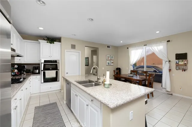 a kitchen with stainless steel appliances kitchen island granite countertop a sink and cabinets