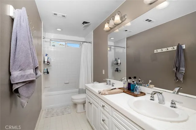 a bathroom with a sink double vanity granite toilet and shower
