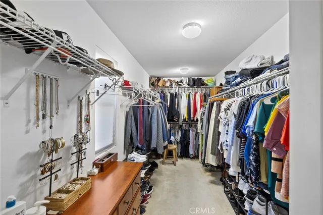 a view of walk in closet with clothes