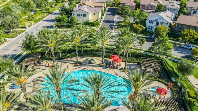 a view of a swimming pool with a lounge chair and palm trees