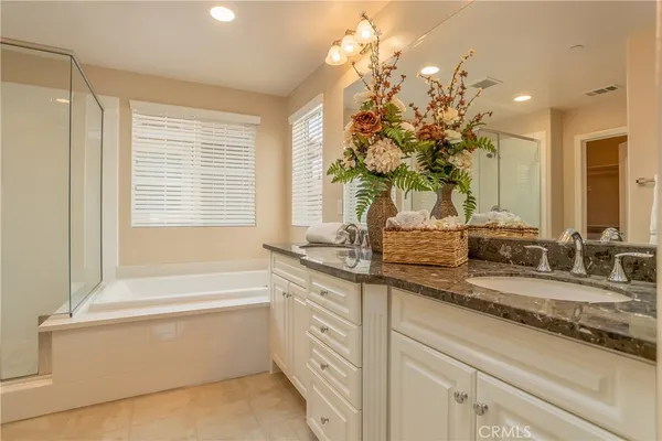 a bathroom with a sink a large mirror and a bathtub with shower