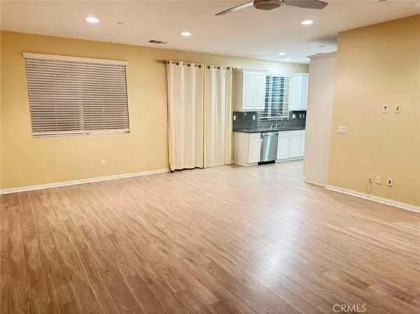a view of a kitchen with wooden floor and electronic appliances
