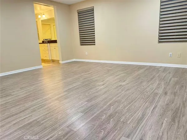 a view of a room with wooden floor and a window