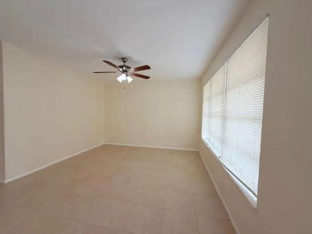 a view of a big room with chandelier fan and windows
