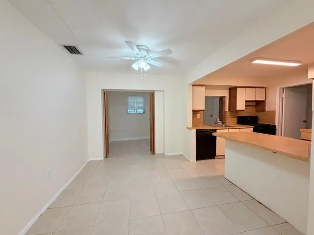 an empty room with a ceiling fan and window