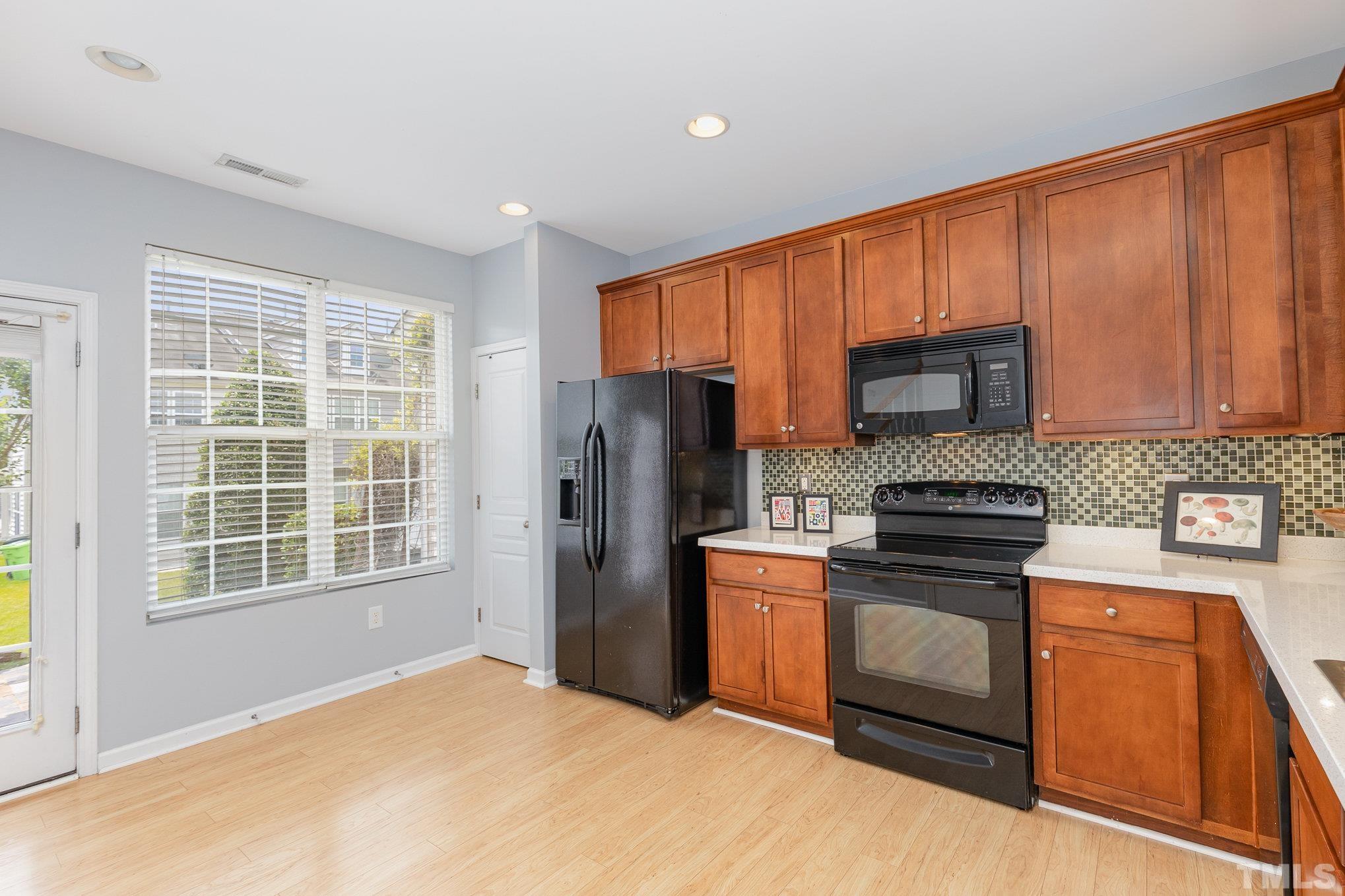 800 Bryant Street Raleigh, NC 27603 - Photo 8 of 20 a kitchen with granite countertop wooden cabinets stainless steel appliances and a window