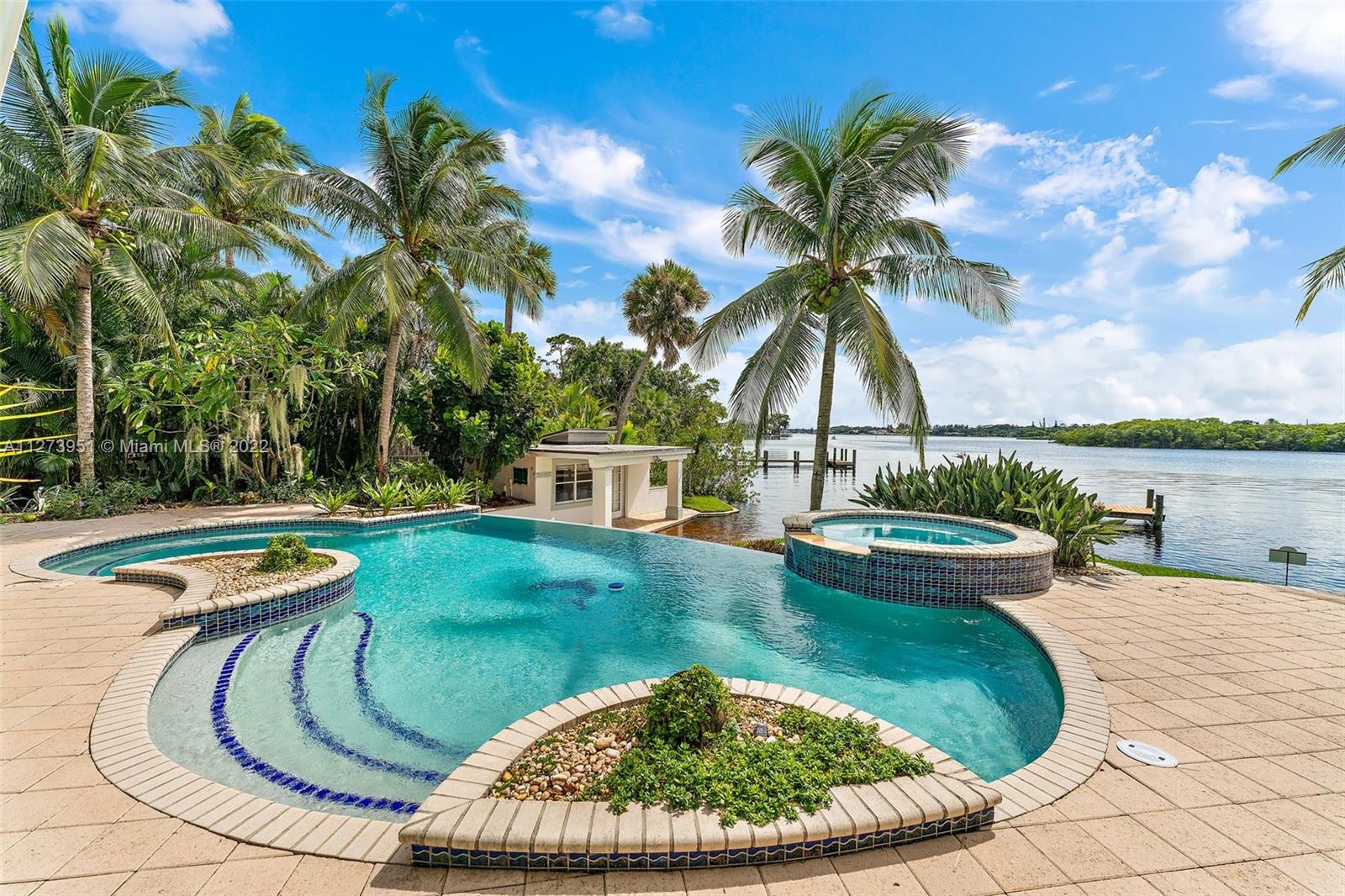 9460 Southeast Point Terrace Jupiter, FL 33469 - Photo 1 of 51 a view of a swimming pool with a lounge chair